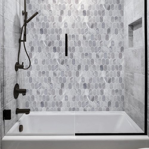 white bathtub with black accessories and gray small tile wall pieces from Traditional Floors in Milan, IL