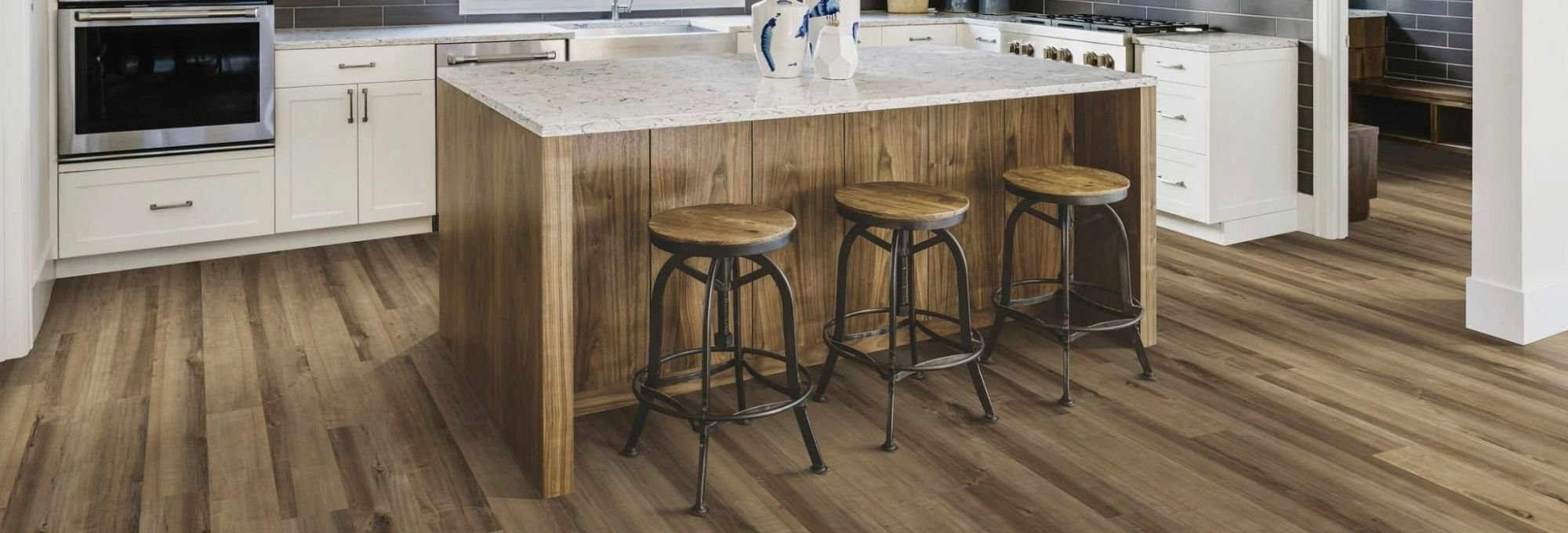 brown kitchen island table with white countertop, white furniture and brown vinyl floor from Traditional Floors in Milan, IL