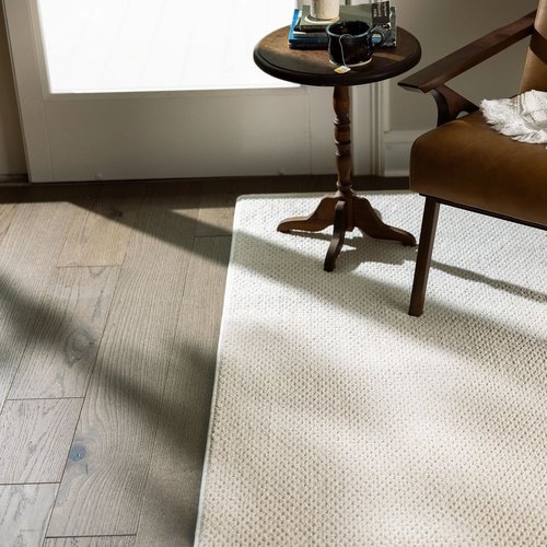 brown armchair and coffee table on white rug from Traditional Floors in Milan, IL